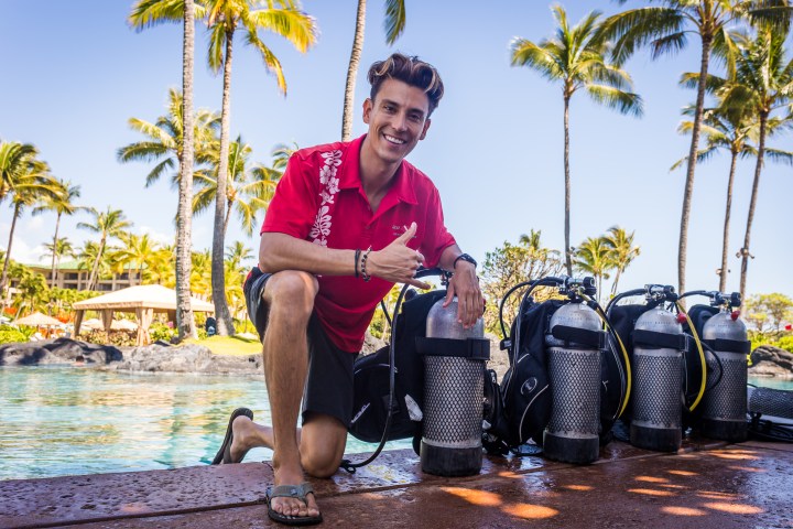 Staff member kneeling next to scuba tanks
