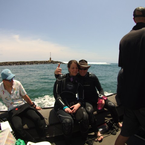 Couple sitting on edge of dive boat