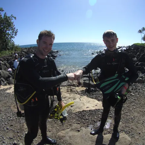 two scuba divers on landing fist bumping each other