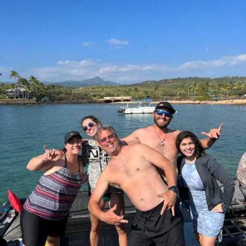a group of people standing next to a body of water